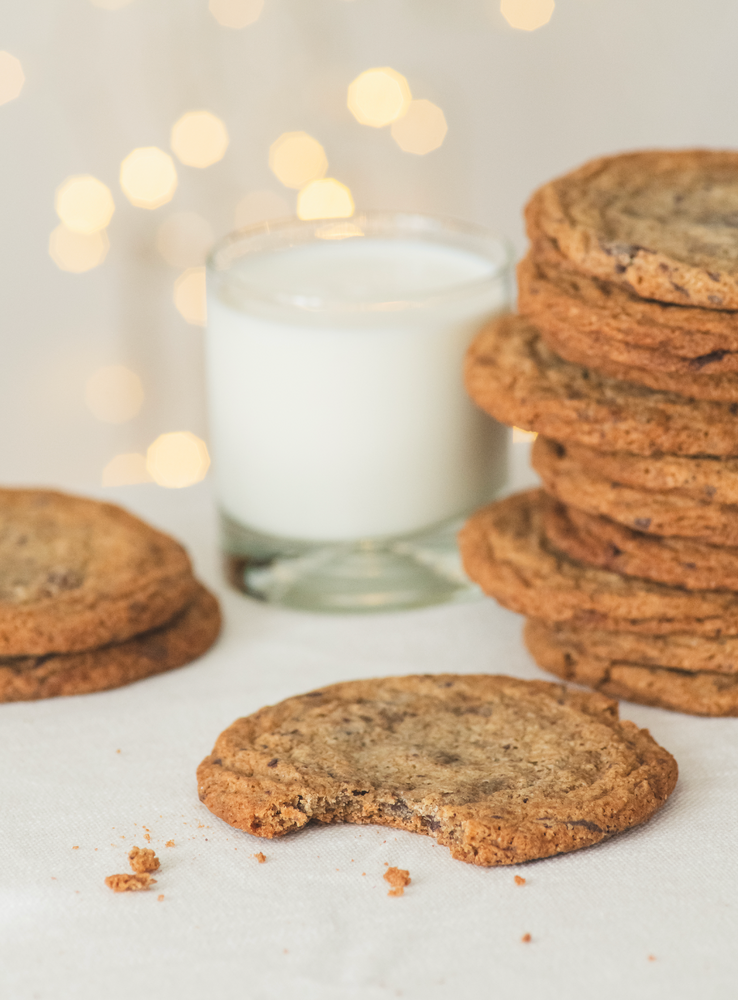 Stacks of cookies with a glass of milk on a light background