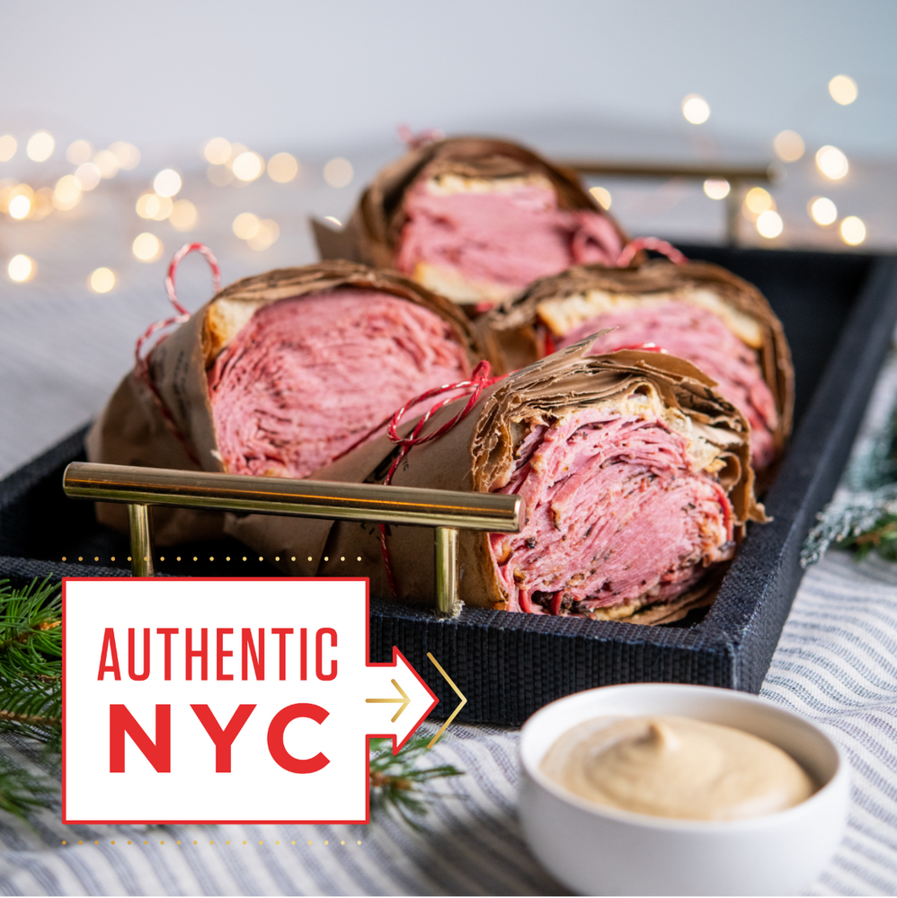 Deli sandwiches on a tray with a small bowl of mustard, Christmas lights in the background, and 'Authentic NYC' text.